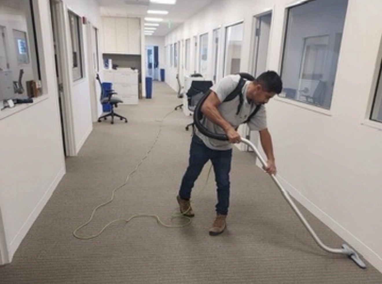 GFM team member vacuuming an office corridor